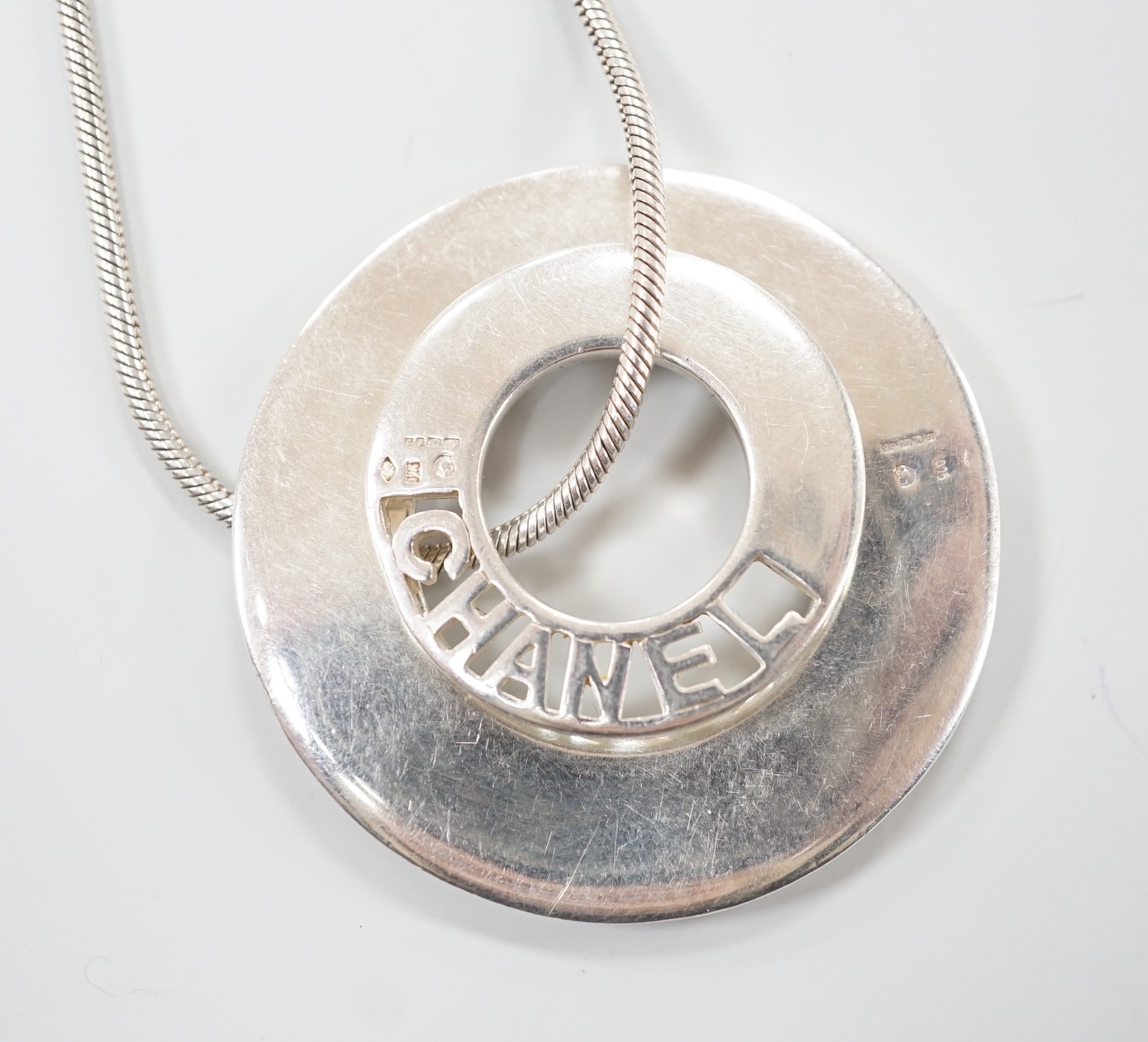 A French silver Chanel graduated double disc pendant necklace, on snake link chain, London import marks for 2001, diameter 44mm, 46.8 grams.